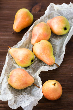Ripe pears in a paper on a wooden table