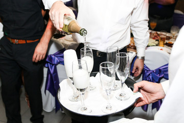 Waiter pouring champagne in glasses at wedding