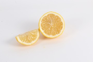 Fototapeta na wymiar halbe Zitrone mit einem Stück liegt auf dem Tisch