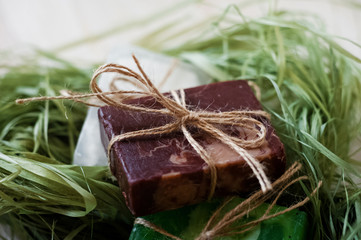 SPA procedures. Multicolored pieces of soap with candles, wax and bath salt. Multicolored pieces of soap are tied with string.  A beautiful colored soap with spruce branches.