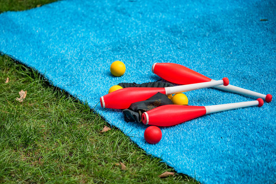 Juggling clubs and balls on lie blue mat close-up