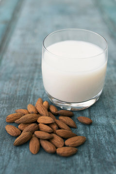 Glass Of Almond Milk On Blue Wooden Background With Almond Nuts