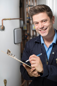 Male Plumber Working On Central Heating Boiler
