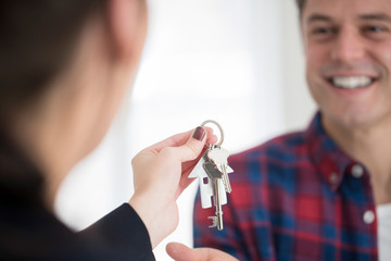 Man Collecting Keys To New Home From Female Realtor