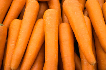 Close up a fresh carrots for background. The Carrot is root vegetable, usually orange in colour, though purple,  yellow cultivars exist.