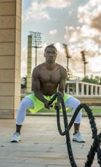 male muscular training with battle ropes