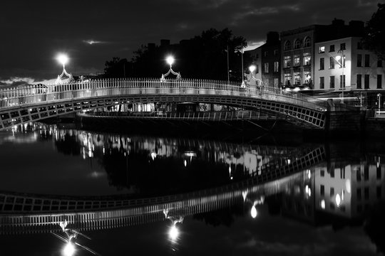Fototapeta Ha Penny Bridge in Dublin, Ireland at night. Black and white