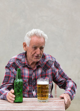 Senior man with beer bottle and mug