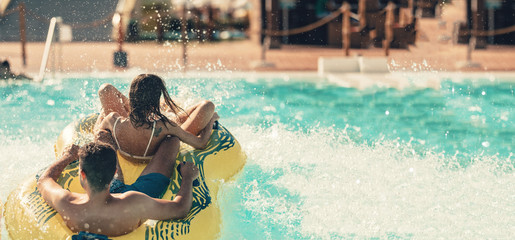 Cool people having fun on the water slide with friends and familiy in the aqua fun park glides...
