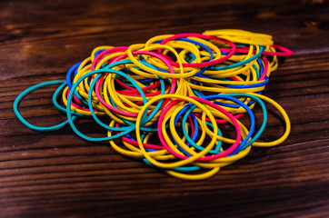 Multicolored rubber bands on wooden table