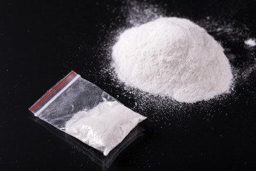 Obraz na płótnie Canvas Cocaine in plastic packet on black background