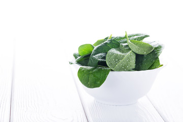 Fresh raw spinach in white bowl