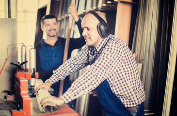 Fototapeta na wymiar Two professional labours working on lathe machine in PVC shop