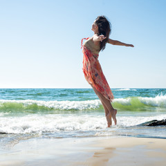 Young woman jumping on the beach