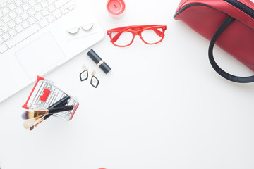 Beauty items in shopping cart with laptop computer on white background, Online shopping