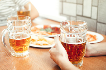 Beautiful beer in a mug holding friends