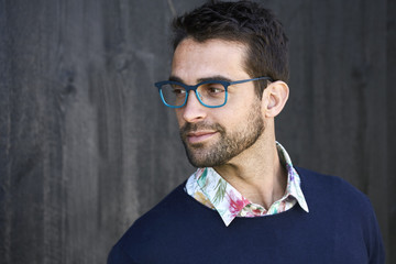 Stubble guy with glasses in sweater, looking away