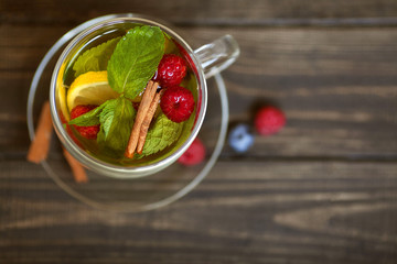 Fruit tea with mint and cinnamon on a wooden background