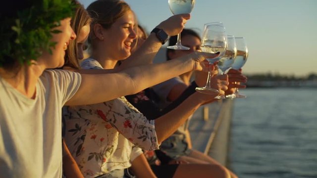 Happy girls talking drinking wine beach party seaside sunrise rapid slow motion