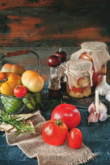 Homemade canned tomatoes in glass jars in a rustic style. The concept of cultivation, harvesting and preservation of vegetables.