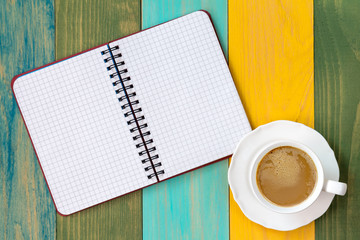 Blank notebook and cappuccino cup