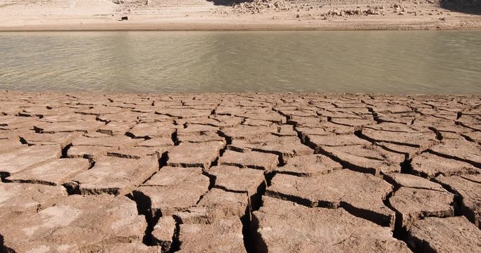 4k video. Landscape of dry earth ground and river with water streaming, in Entrepenas reservoir, in Guadalajara, Castilla, Spain Europe
