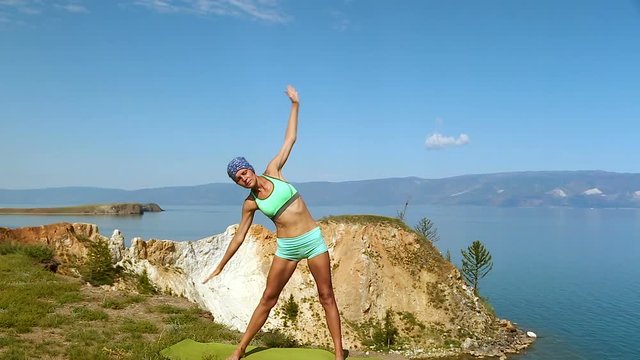 Young Woman Standing Yoga Pose at the edge of the cliff Healthy Active Lifestyle.