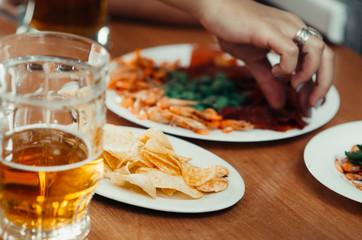 On the table is a beer next to the snack