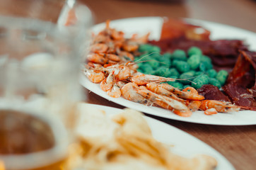 On the table is a beer next to the snack