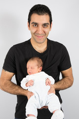 Young father at home holding his newborn baby girl or boy