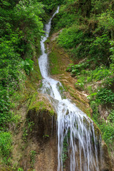 a small waterfall runs down cliff
