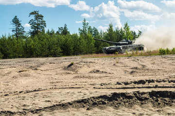 Fototapeta na wymiar Main battle tank are going to dust on the ground for military exercises