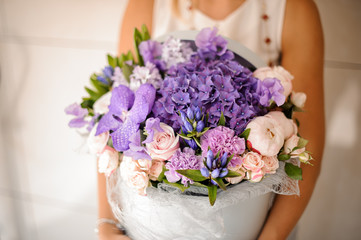 Hands with a beautiful purple composition of flowers