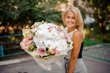 Fototapeta premium Pretty girl holding a beautiful composition of flowers