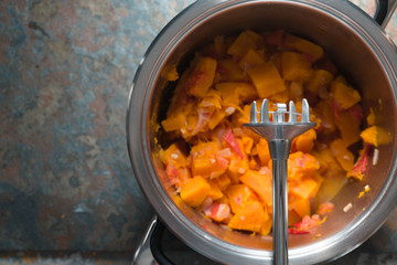 Casserole with ingredients for pumpkin soup and blender