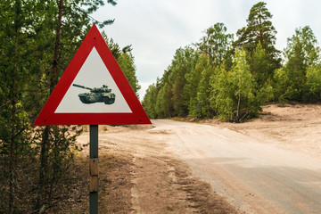 Saint Petersburg, Russia - June 30, 2017: road sign caution tanks on a country road in the woods. focus on a road sign