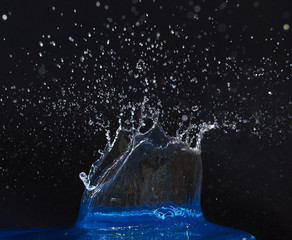 Splash of water crown on blue surface.