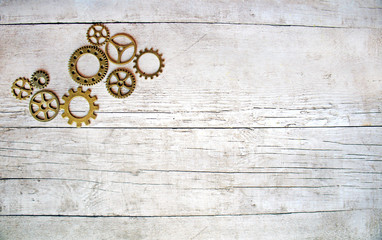 Gears on a grey white wooden background, mechanical flat lay with copy space, steampunk style