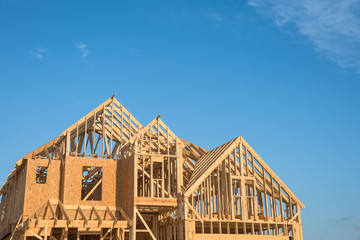 Close-up of gables roof on stick built home under construction and blue sky in Humble, Texas, USA....