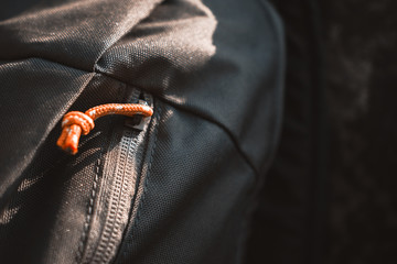 Close-Up Of Olive Green Backpack With Orange Zipper Placed On A Rock