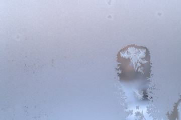  Frosty winter window glass, thawed spot with snowflakes inside and copy space.