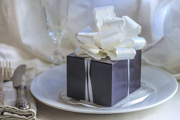 gift box with white bow on a white plate