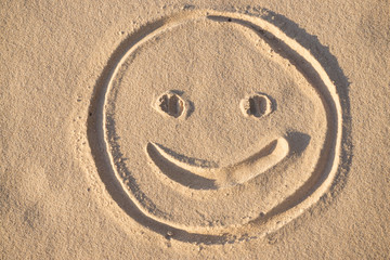Fototapeta na wymiar Prints of emoji smile in the sand on the beach of the Baltic Sea in summer: summer is almost gone, waiting for autumn.