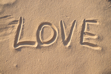 Inscription love on the sand on the beach of the Baltic Sea in summer: summer is almost gone, waiting for autumn.