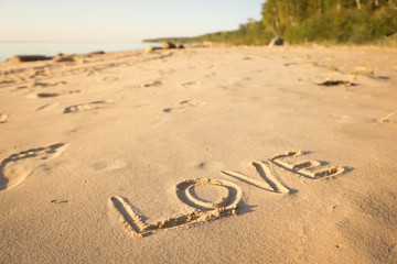 Inscription love on the sand on the beach of the Baltic Sea in summer: summer is almost gone, waiting for autumn.