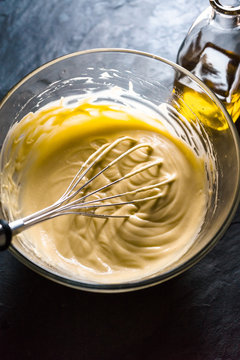 Homemade mayonnaise in a glass bowl and olive oil
