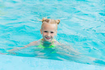 Beautiful girl in a swimsuit swims in the pool