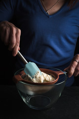 Spoon in hand, bechamel sauce in a sieve side view