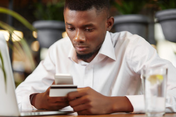 Businessman buying in internet store and paying with card.