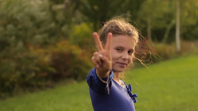little girl showing a hand a peace symbol